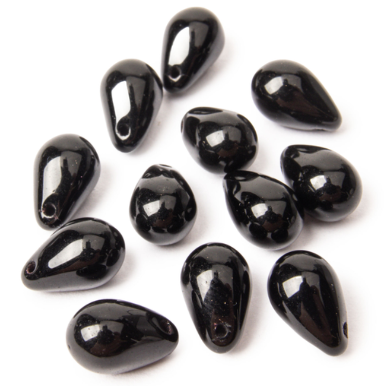 Jet black drop beads on white surface