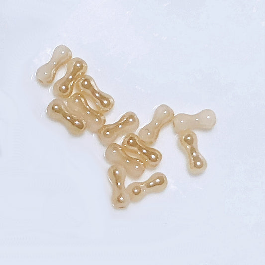 Skleněné korálky ve tvaru arašídů / kosti, béžový zlatý lesk, 8 x 3 mm - 13 korálků