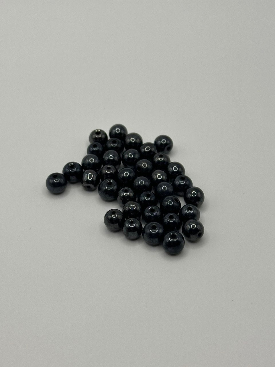 Grey hematite beads on a gray background