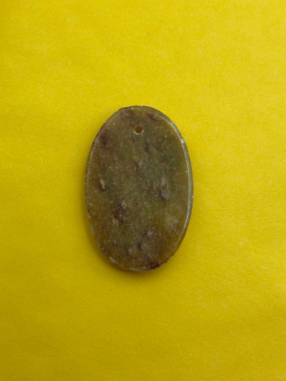 Oval-shaped stone object on a yellow background