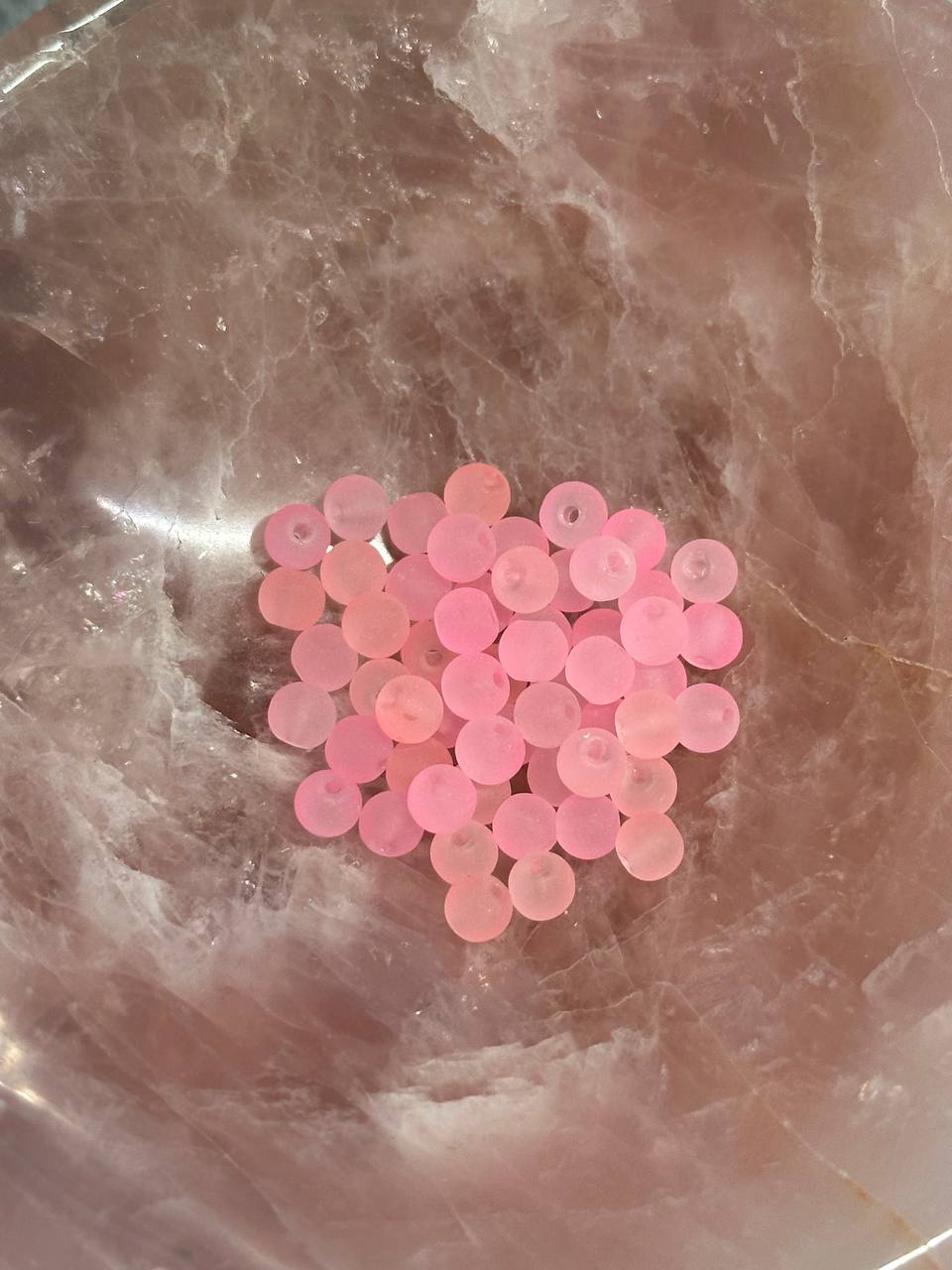 Pink beads on a marbled surface