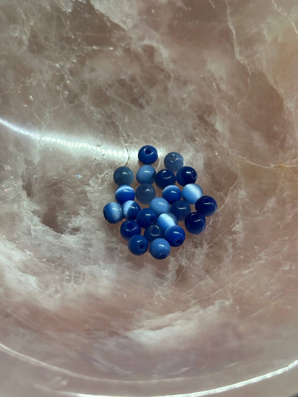 Blue cat eye beads on a marble surface