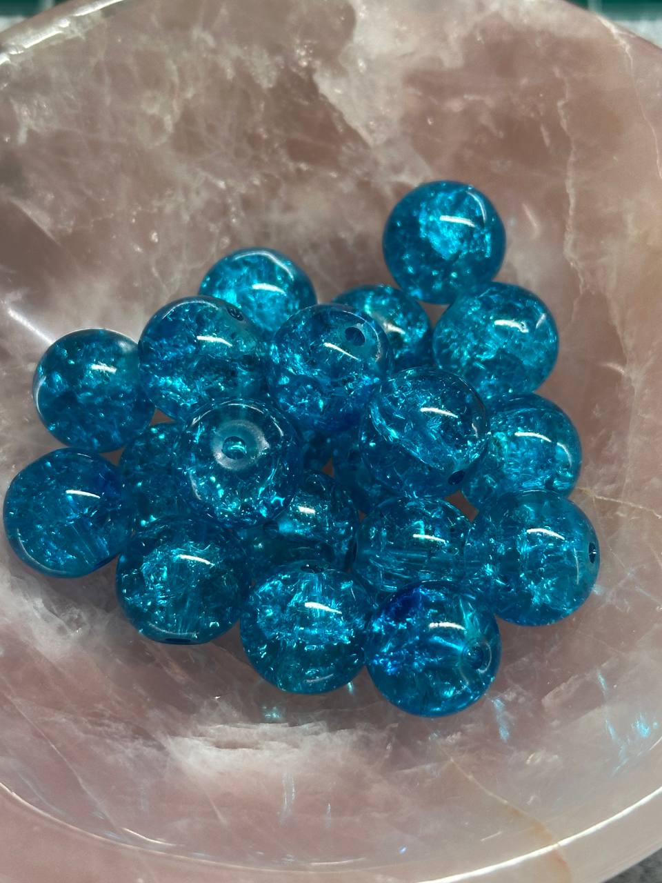 Blue glass beads on a textured stone surface