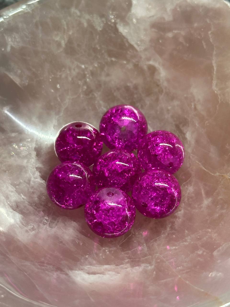 Purple glittery beads on a reflective surface