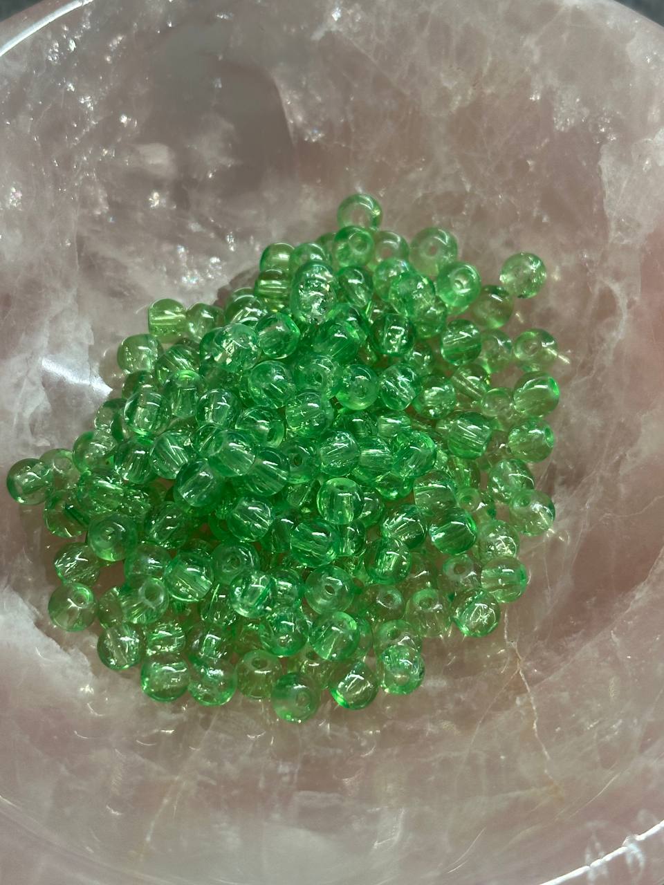 Green beads on a reflective surface