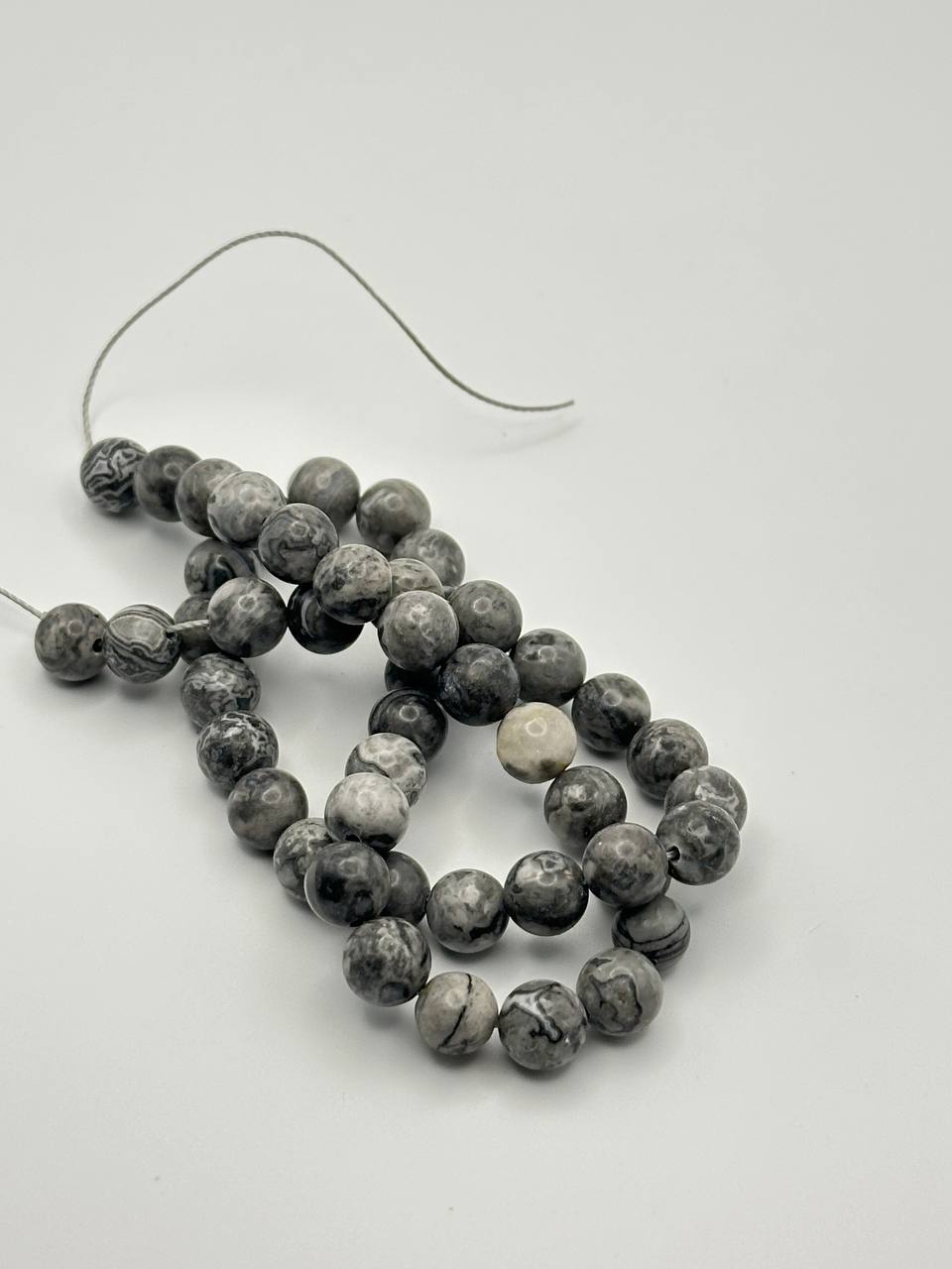 Black, white and grey round beads on a white surface