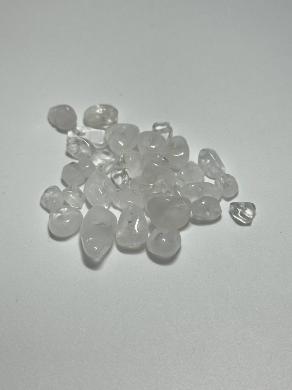 A small pile of clear quartz chips on white background