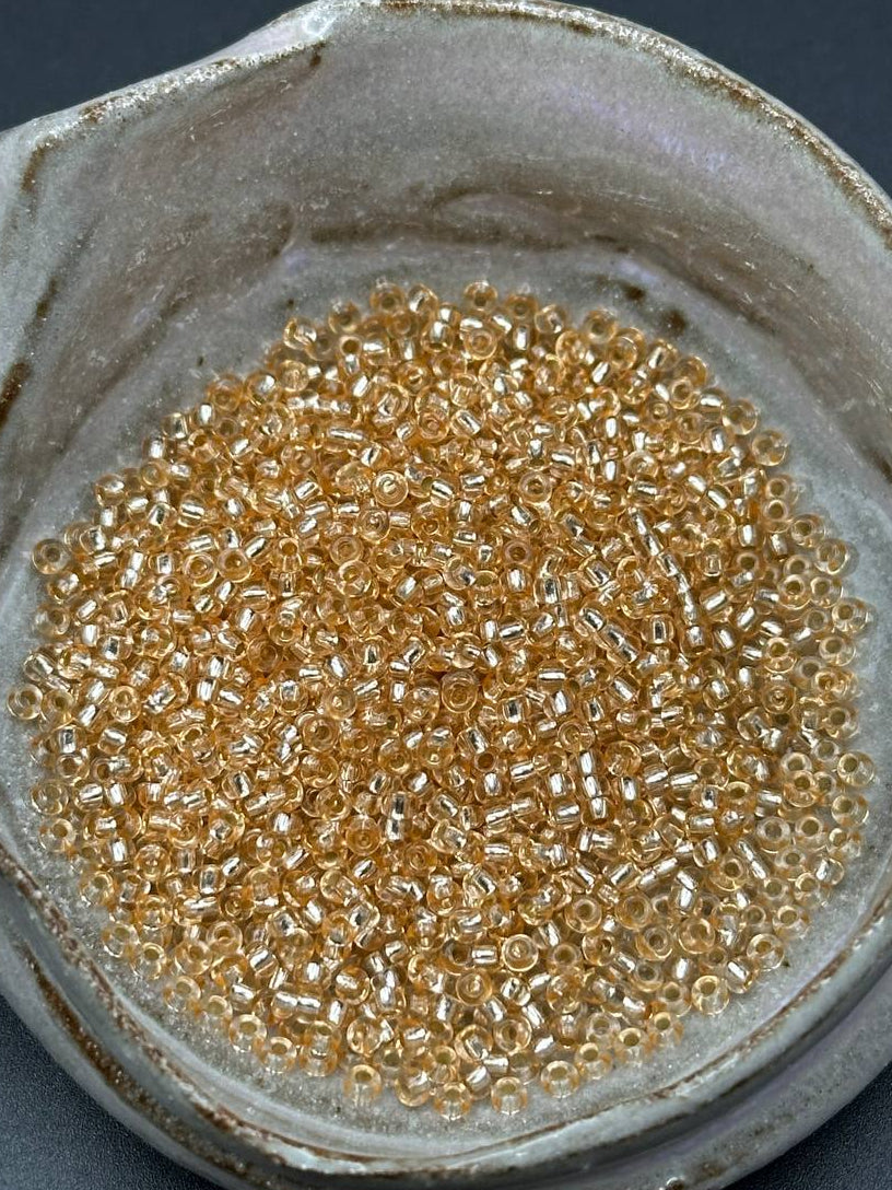 champagne lined seed beads in a grey container