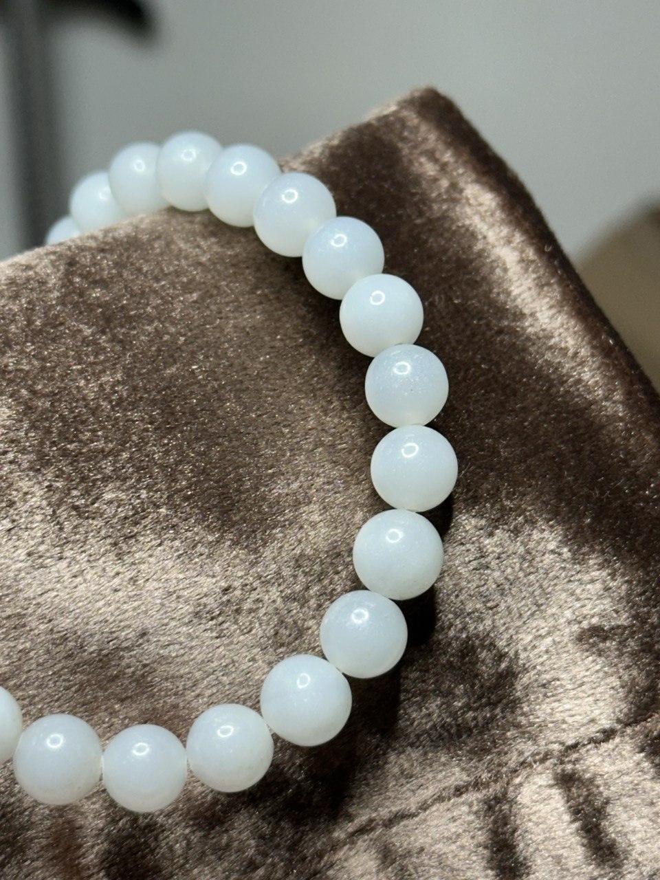 White beads with luster on a brown textured surface