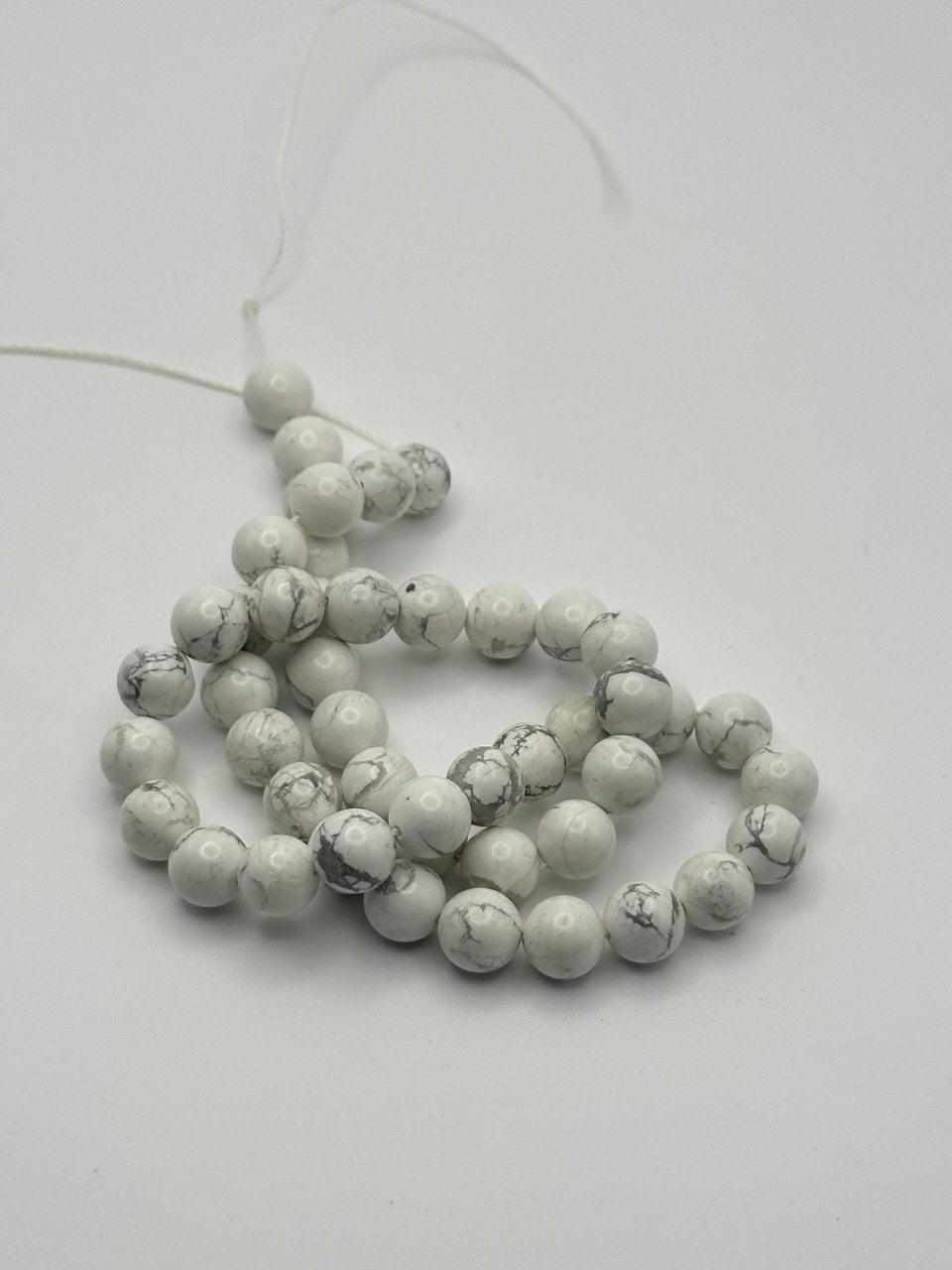 String of white beads on a white background