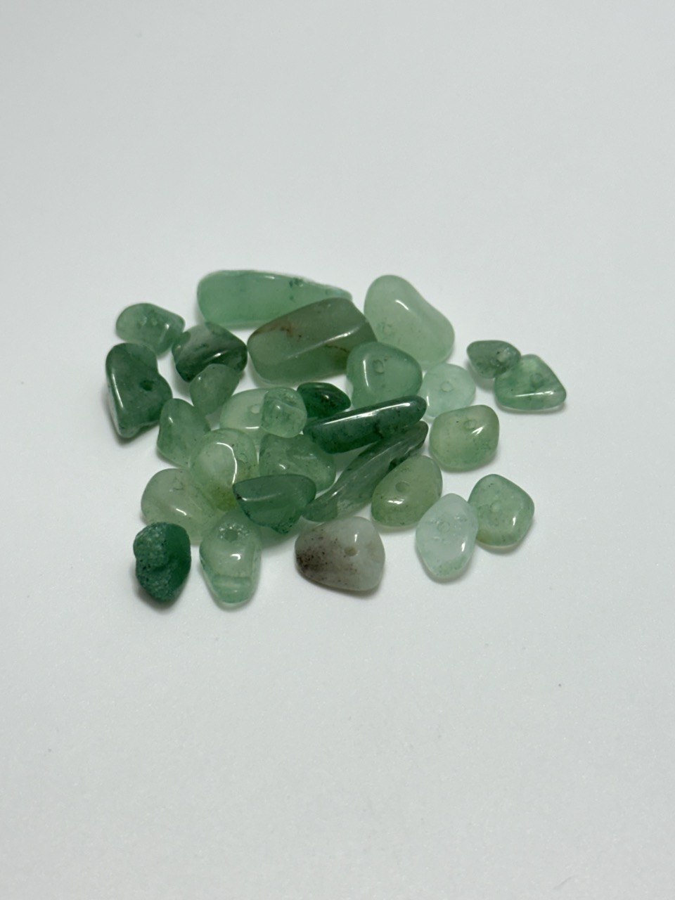 A small pile of aventurine chip beads on white background