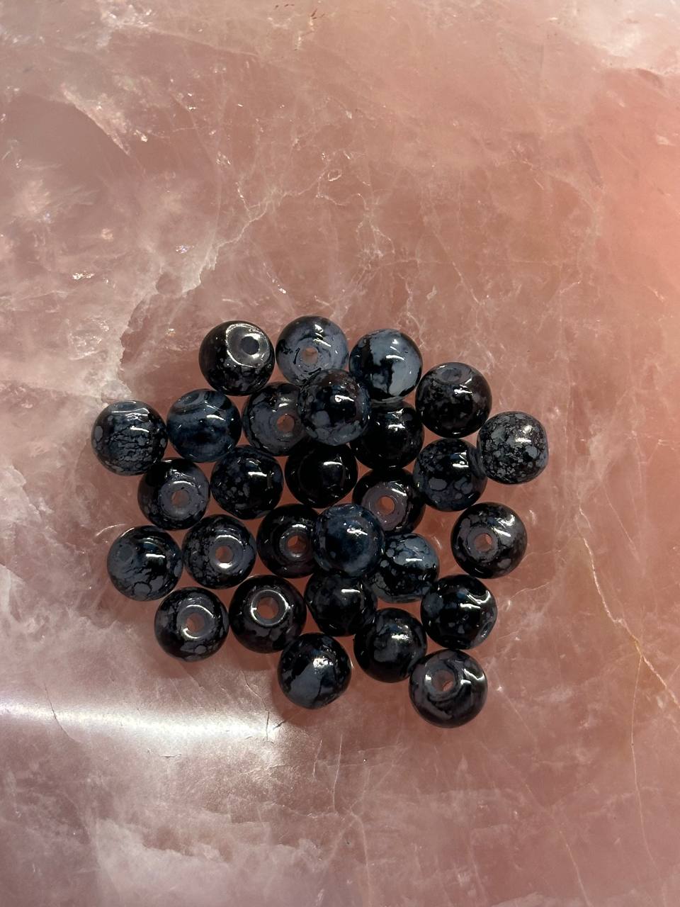 Black beads on a textured pink surface