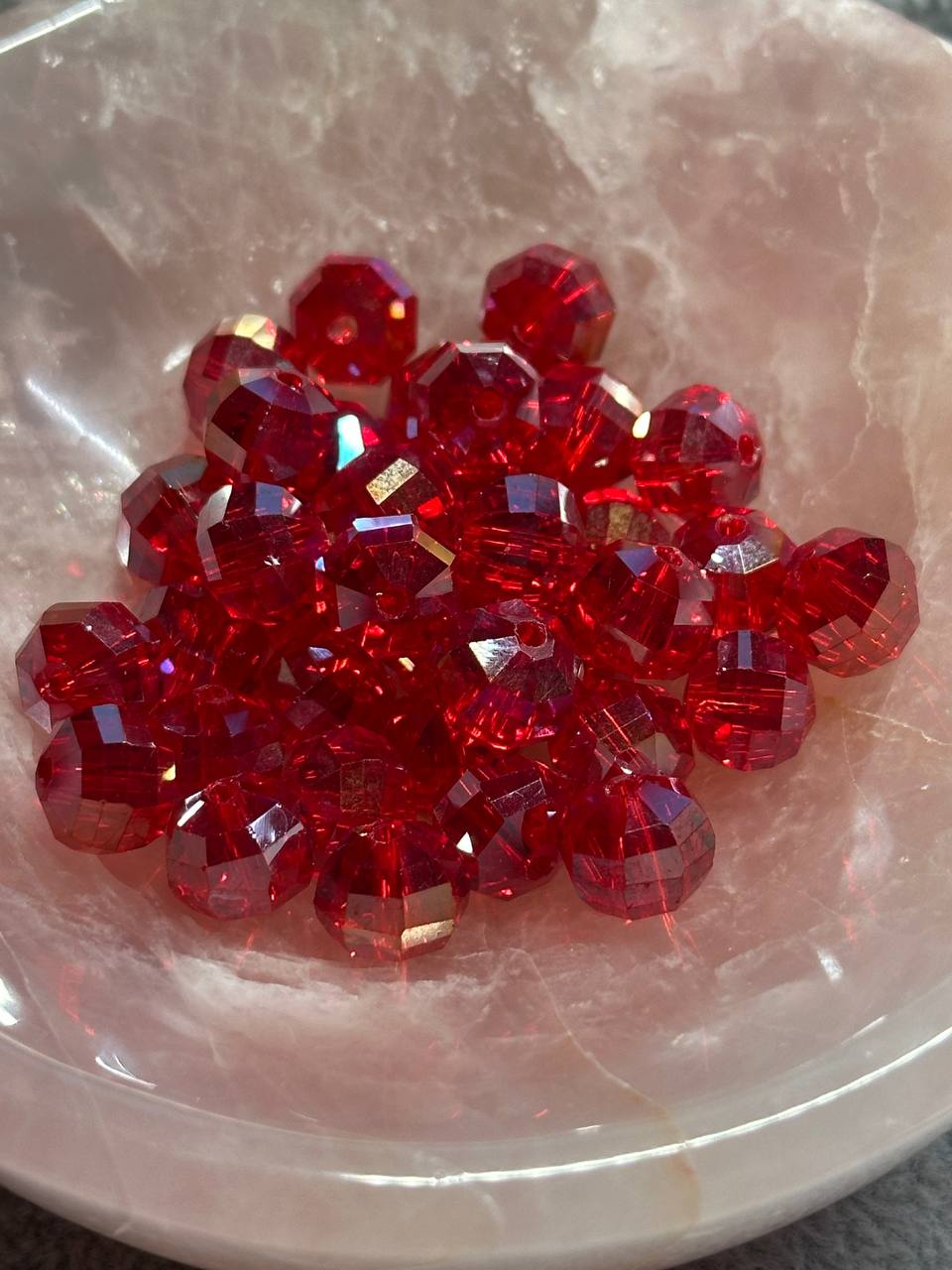 Red glass beads on a textured white surface