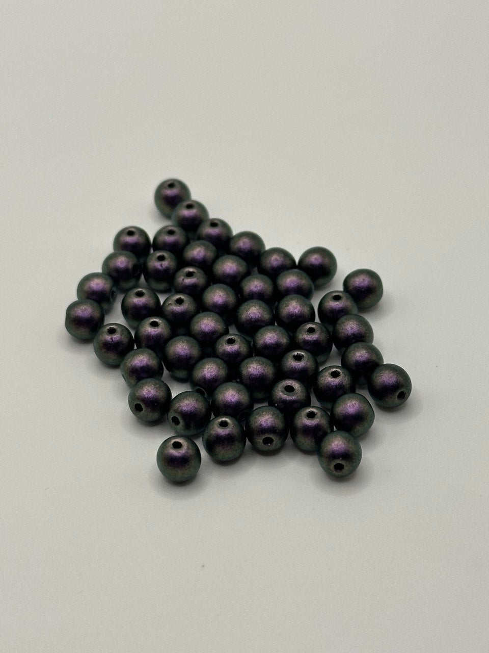 Collection of polychrome black currant beads on a white background