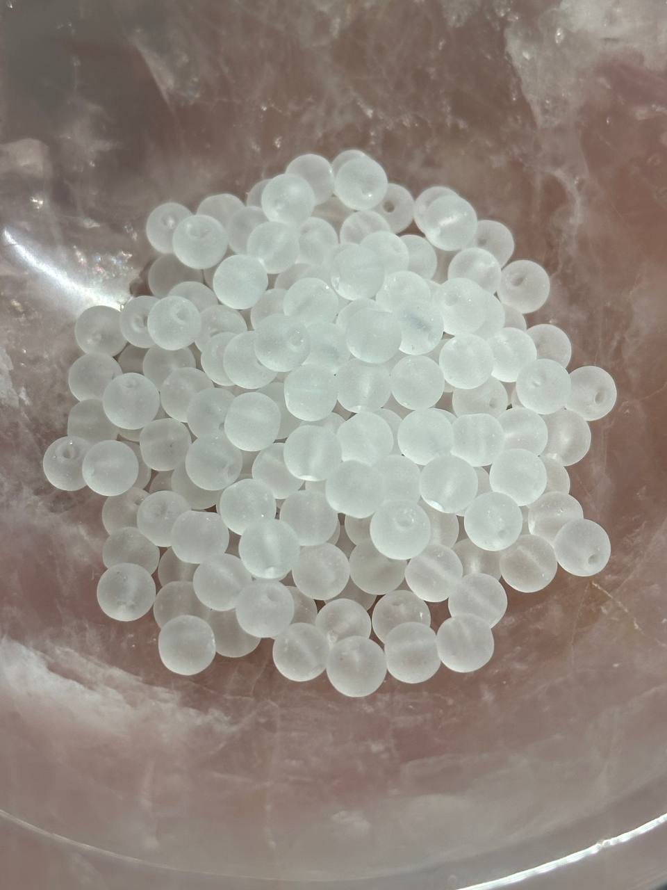 Clear white beads on a reflective surface