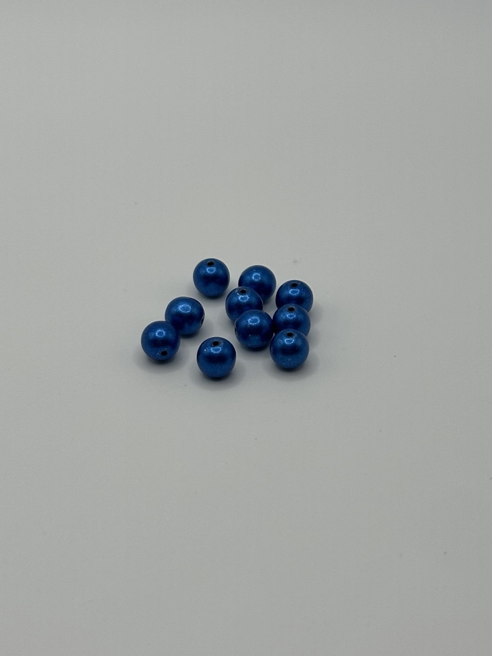Blue metallic beads on light background