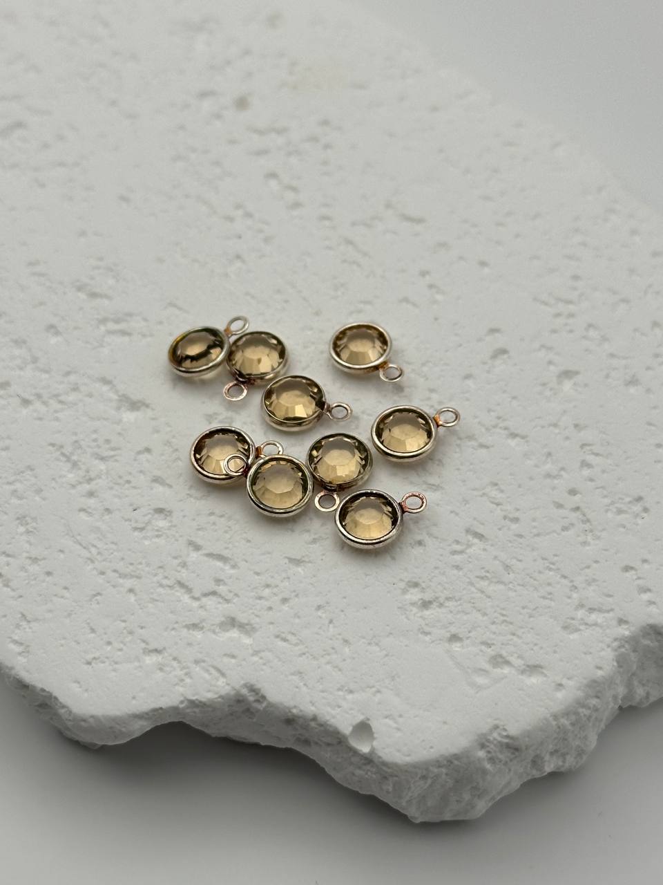 Gold jewelry components on a textured white surface