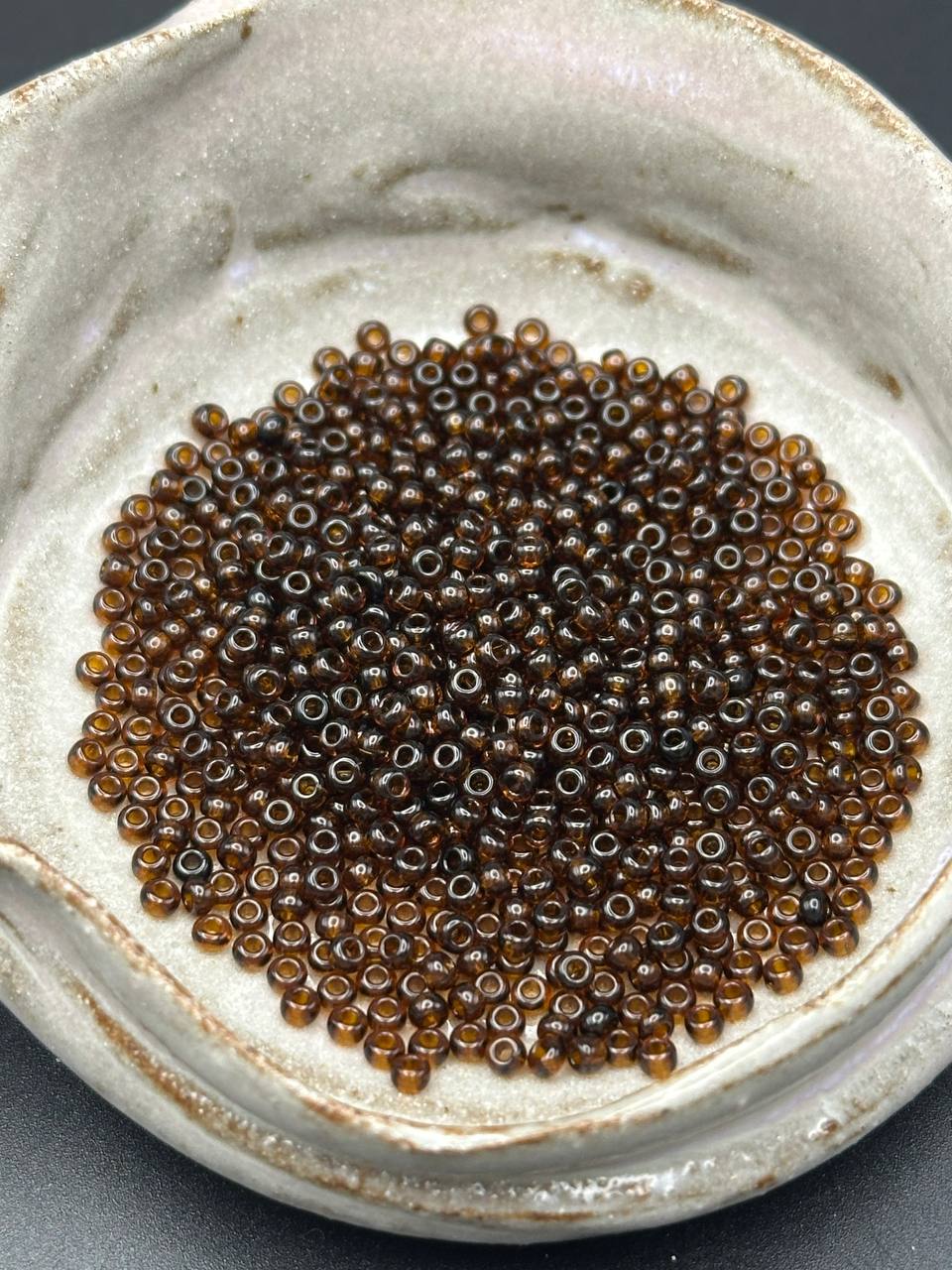 Small brown beads on a textured ceramic plate