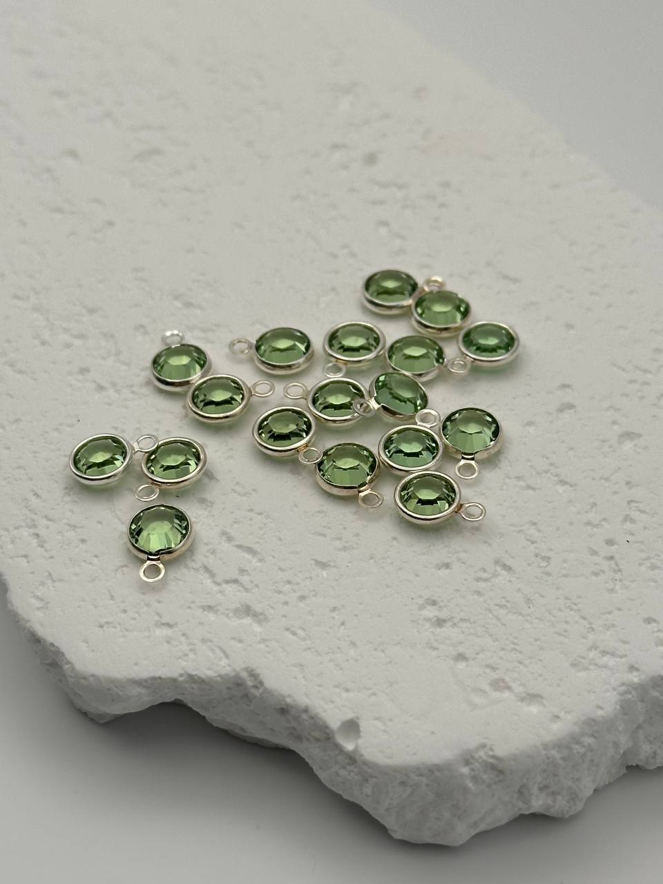 Green charms on a textured stone surface