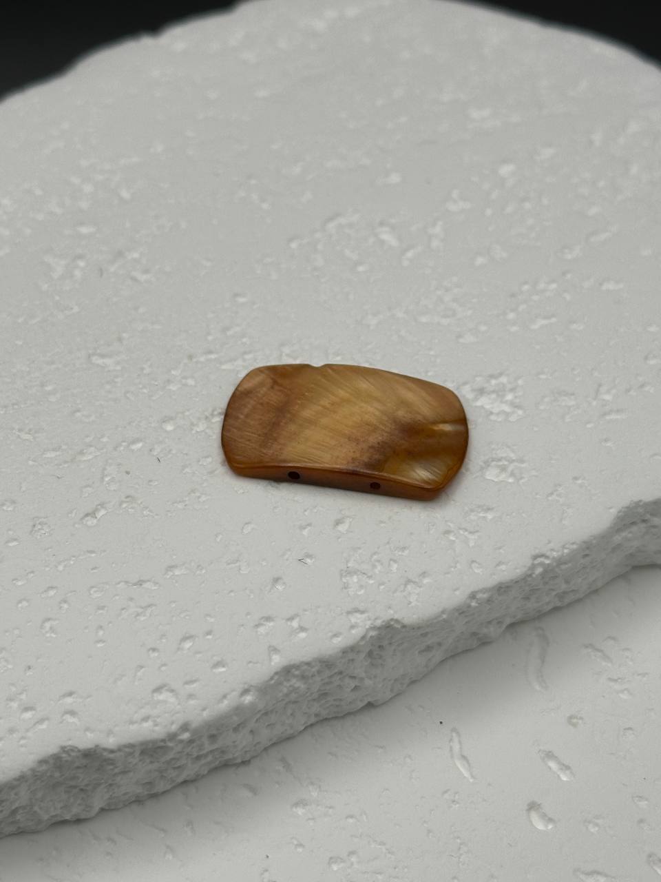 Brown pearl on a textured white surface