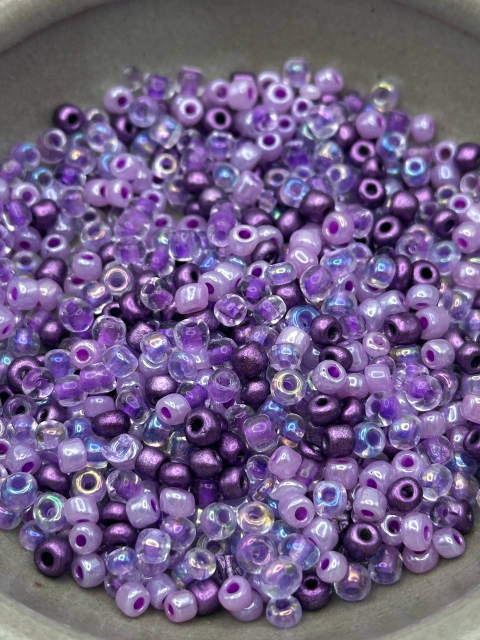 Purple and lavender glass beads on a gray surface