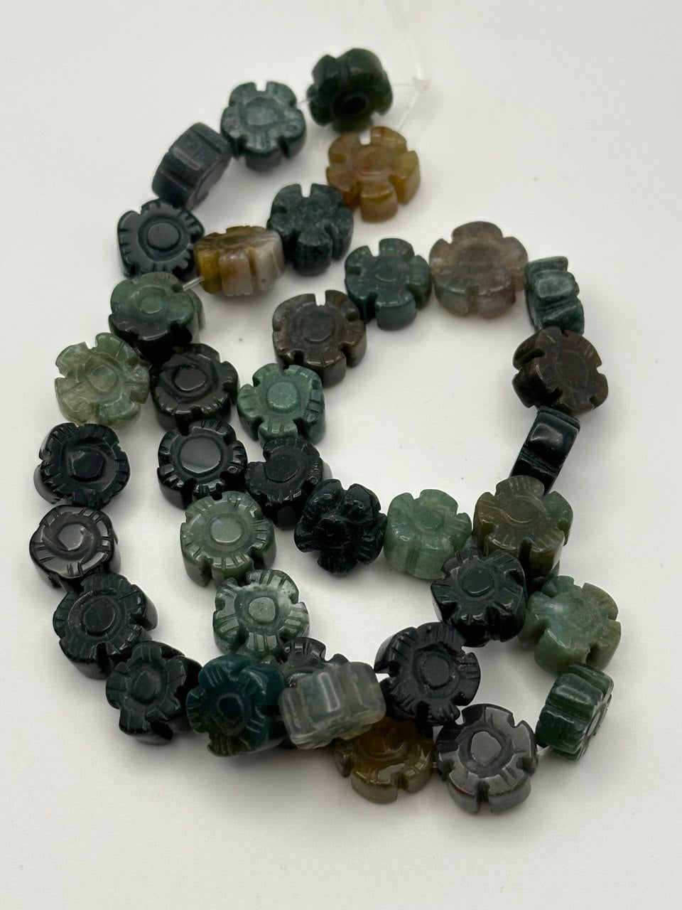 multicolor carved flower semi-precious beads on a white surface