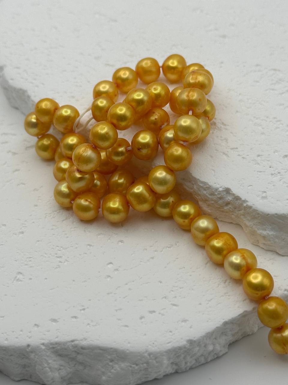 Gold pearls on a textured stone surface