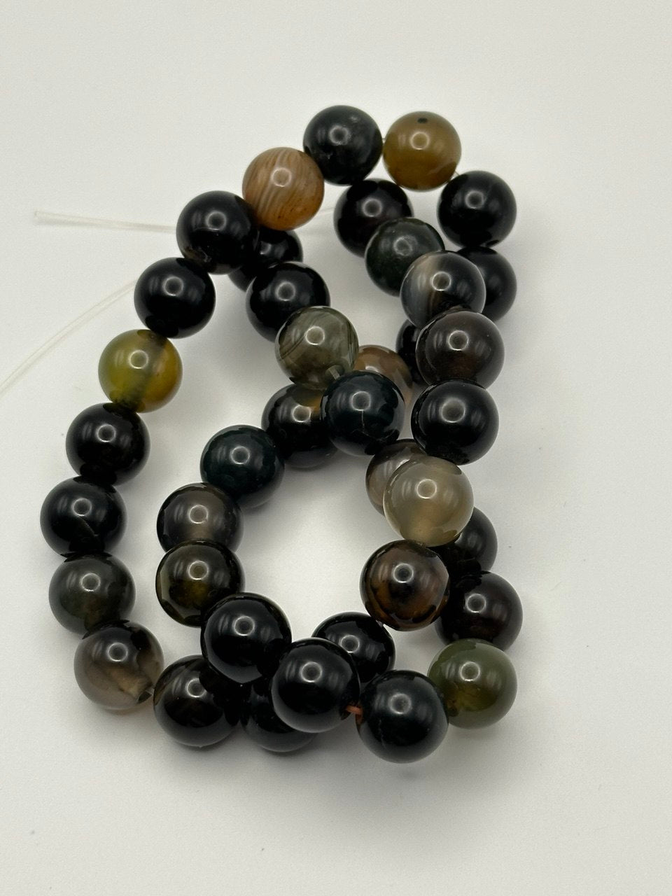 eye agate round smooth finish beads on white surface