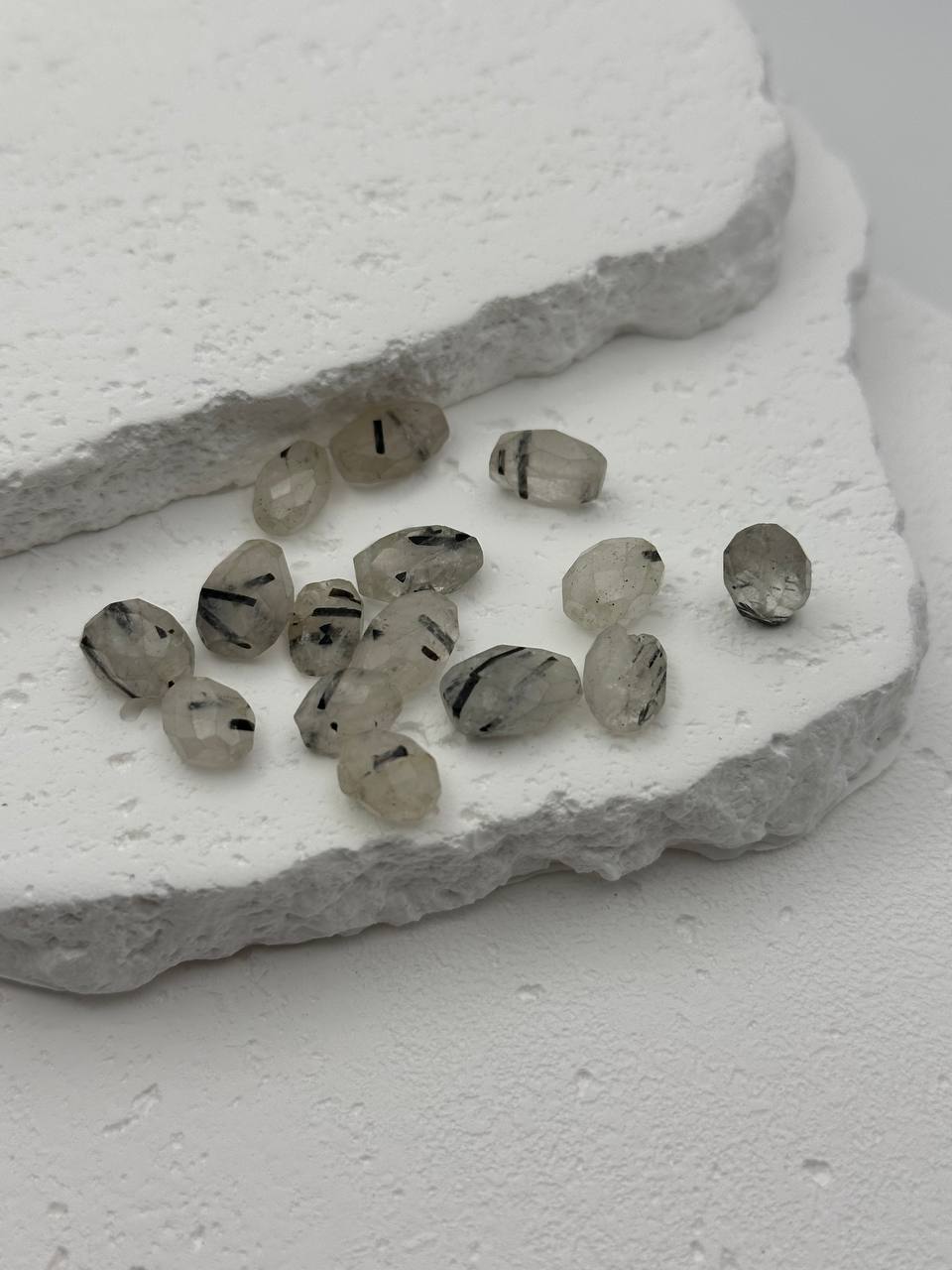 Set of small, oval-shaped stones on a textured white surface