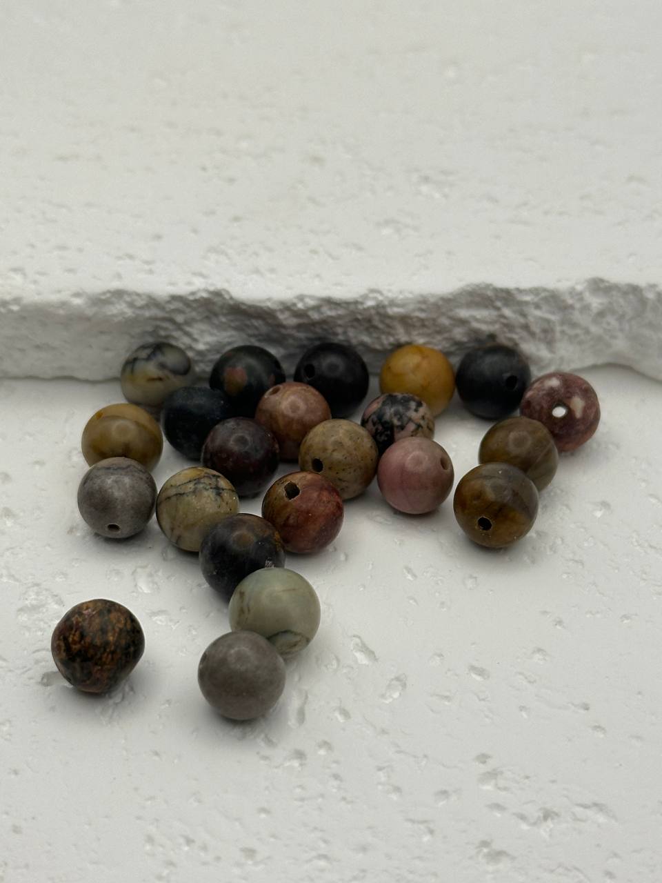 Assorted colored beads on a light gray surface