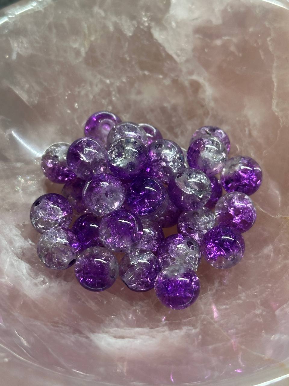 Purple and clear glass beads on a pink crystal background