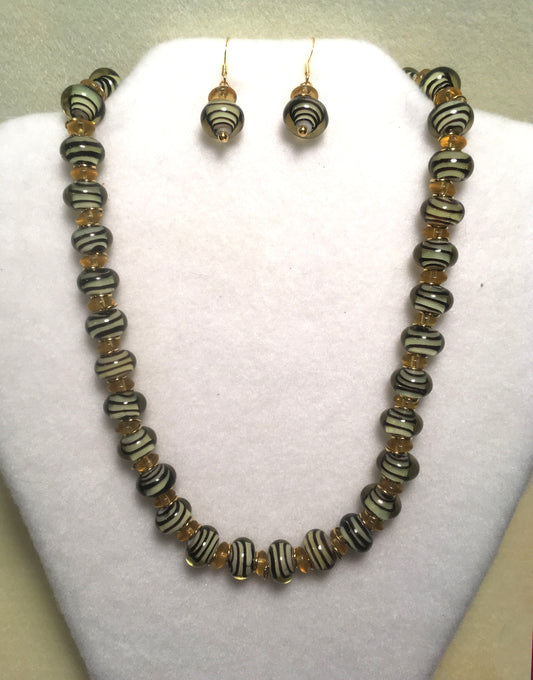 Ensemble collier et boucles d'oreilles tourbillons noirs en verre doré