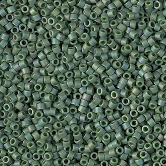A close-up, top-down view of numerous small metallic green seed beads densely packed together.