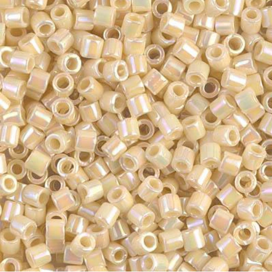 A dense pile of small cylindrical seed beads with a glossy, iridescent pearlescent finish in a light cream or champagne color.