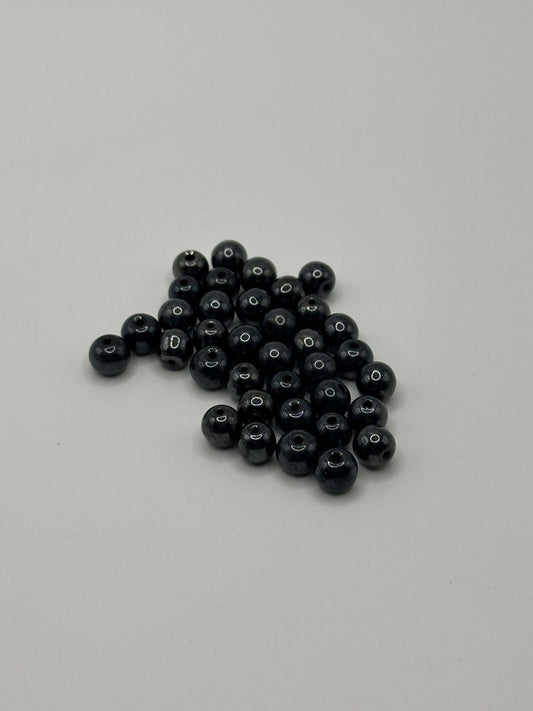 Grey hematite beads on a gray background