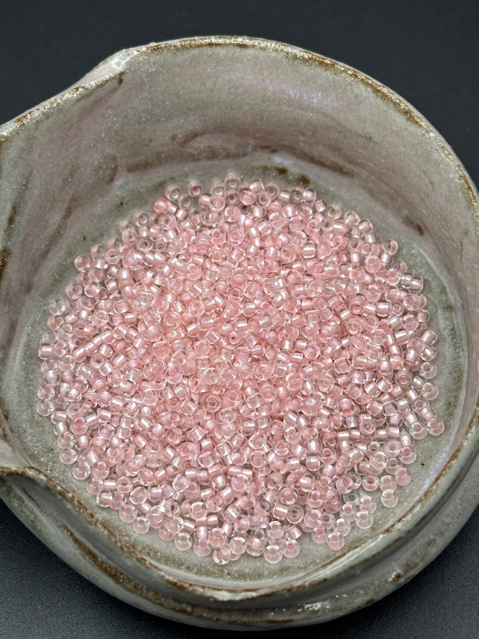 small container filled with rose colored beads