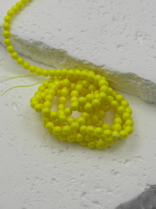 Neon yellow beads on a textured white surface