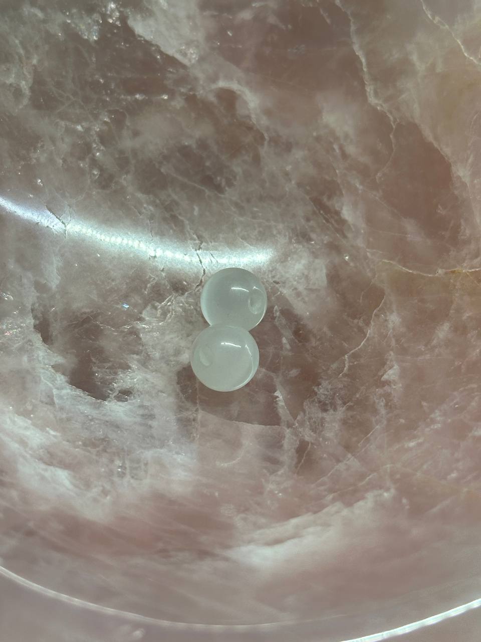 Two clear gel-like beads on a marbled surface