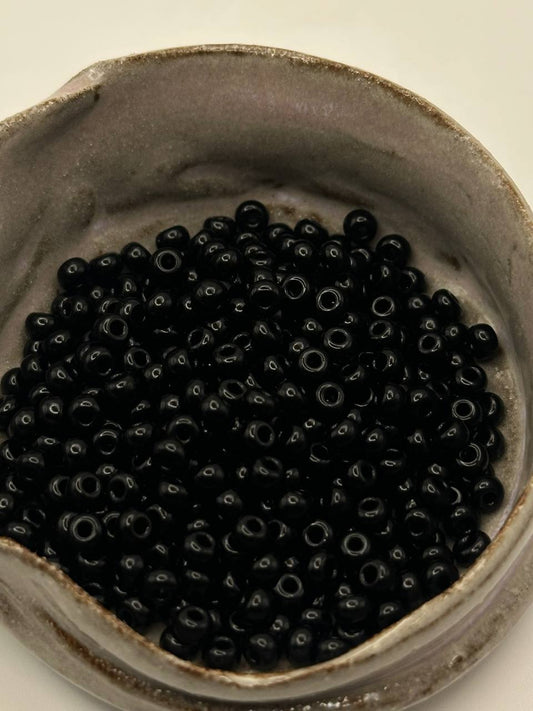 opaque black beads in a ceramic dish