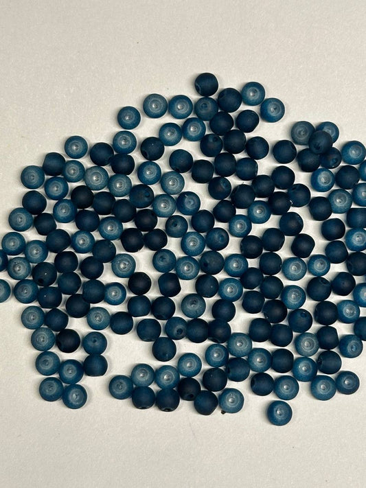 Pile of teal beads on a light gray background