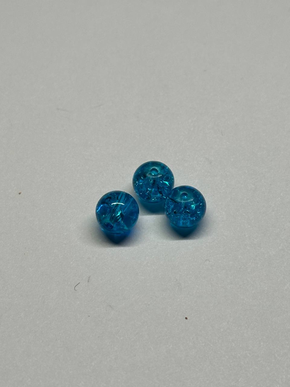 Three blue beads on a light gray background