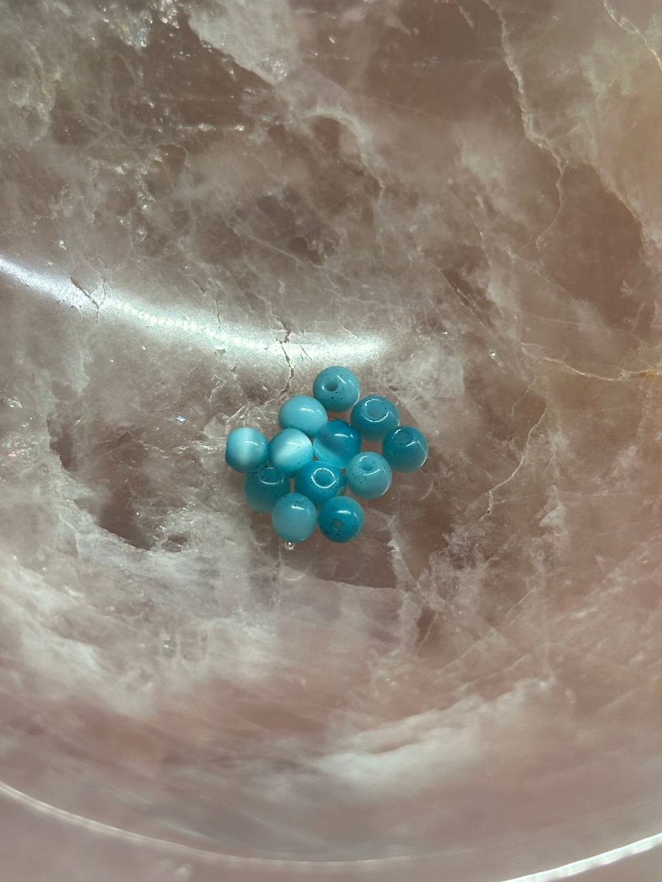 Turquoise beads on a marble surface