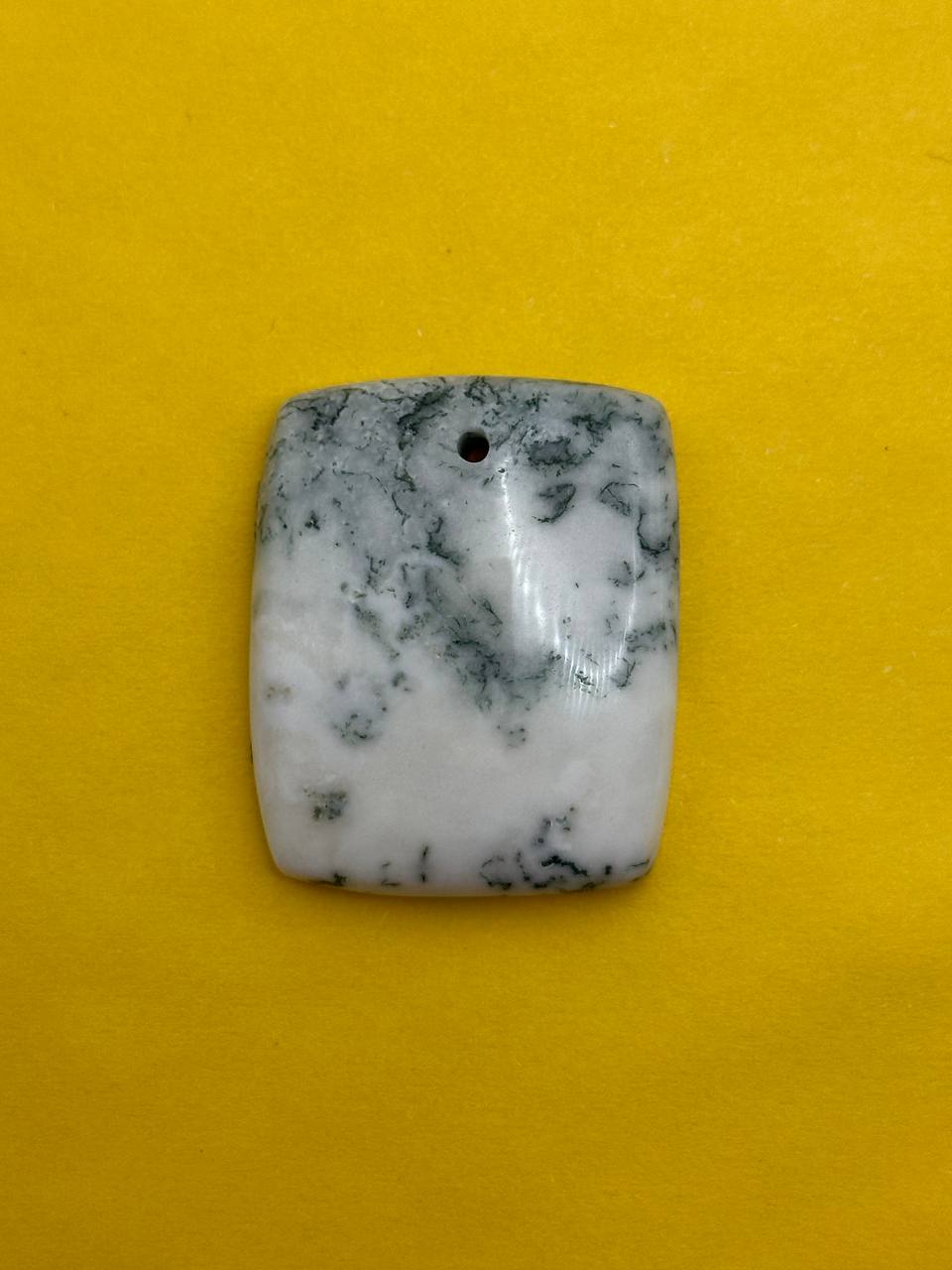 Marble-patterned stone pendant on a yellow background