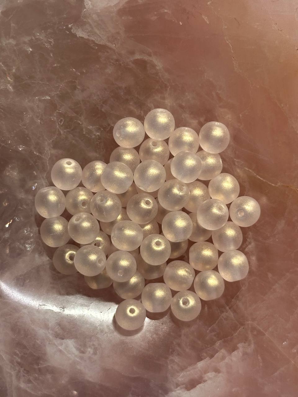 Light pink pearls on a textured pink surface