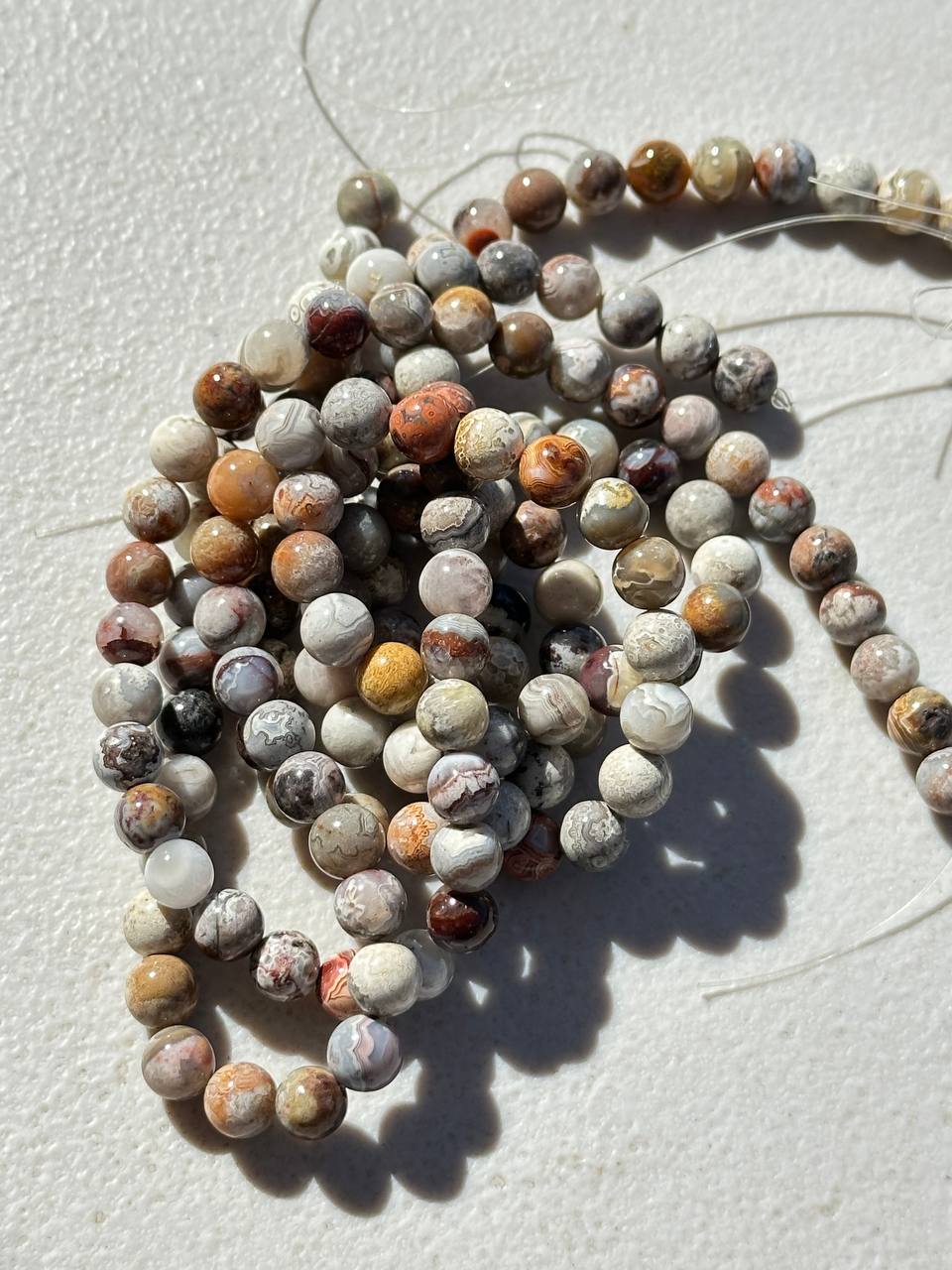 String of multicolored crazy lace agate beads on a light background