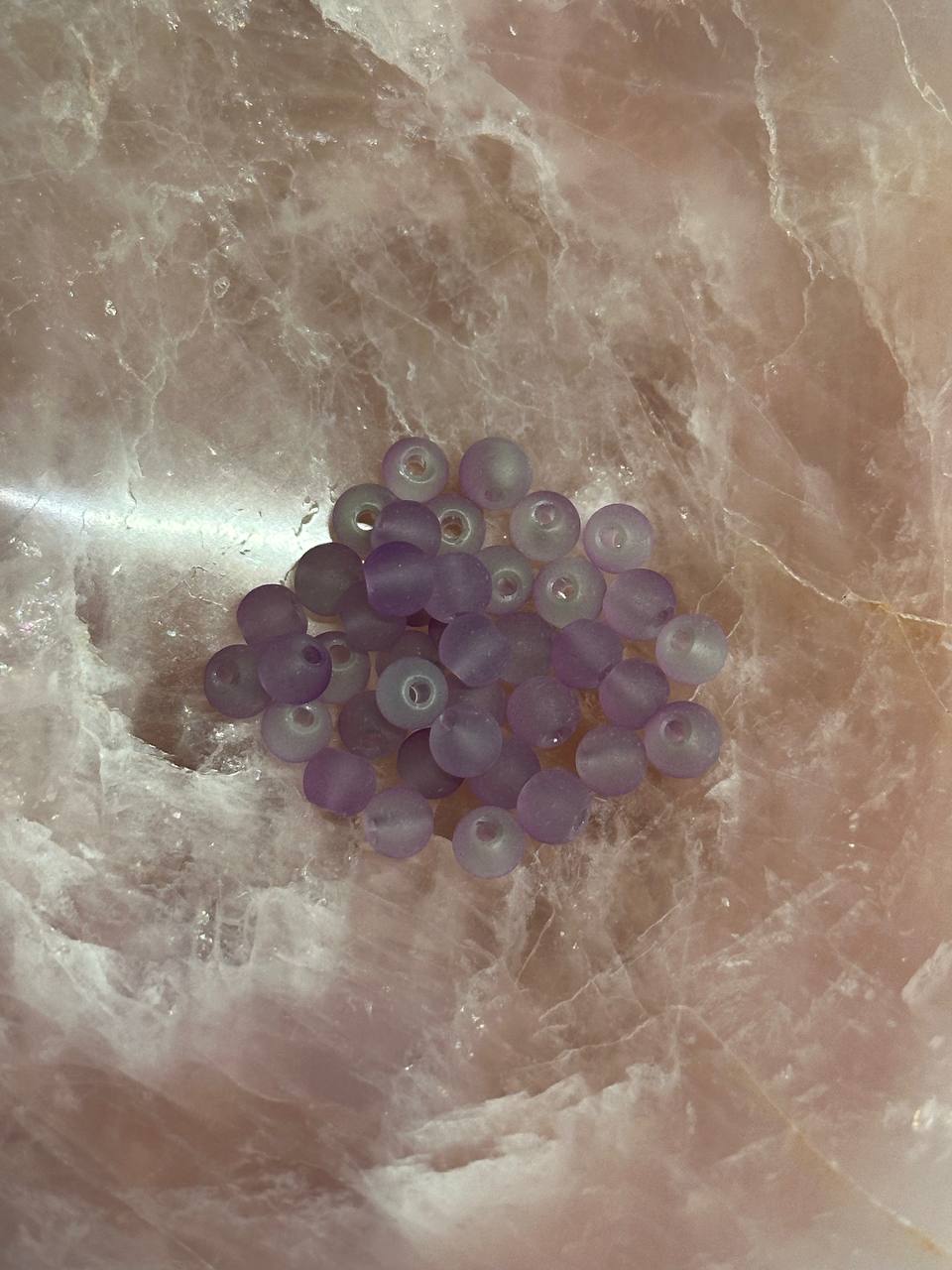 Light violet beads on a marble surface