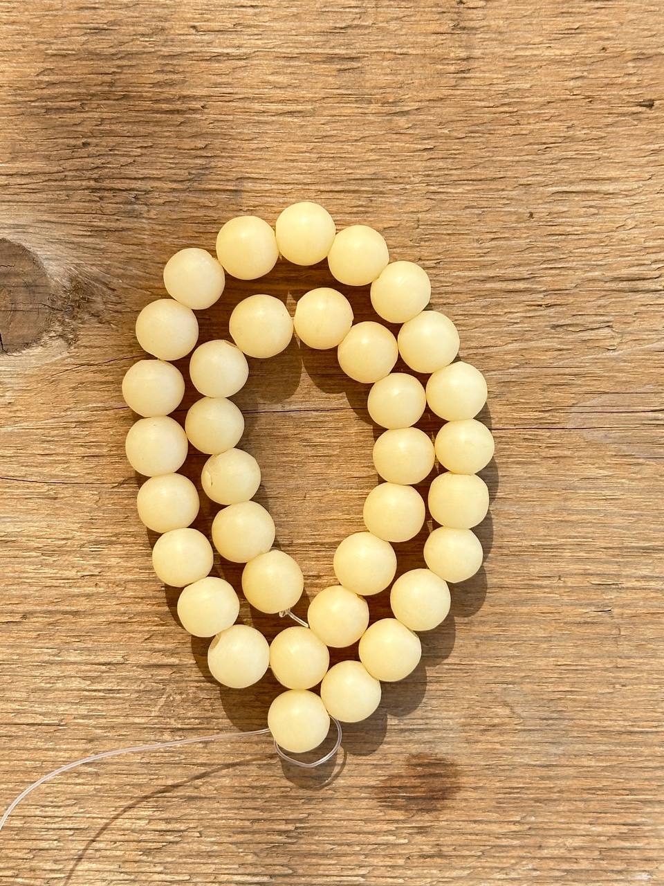 Yellow matte calcite beads on wooden surface