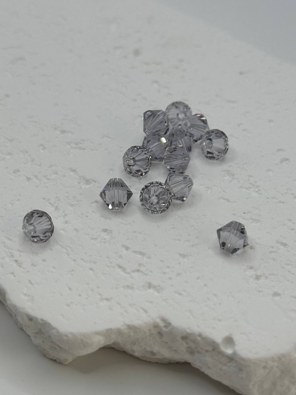 Smoky mauve bicone beads on a textured white surface