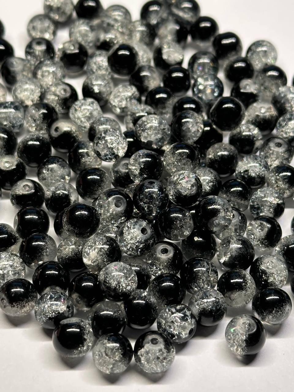 Close-up of black and silver glittery beads on a white background