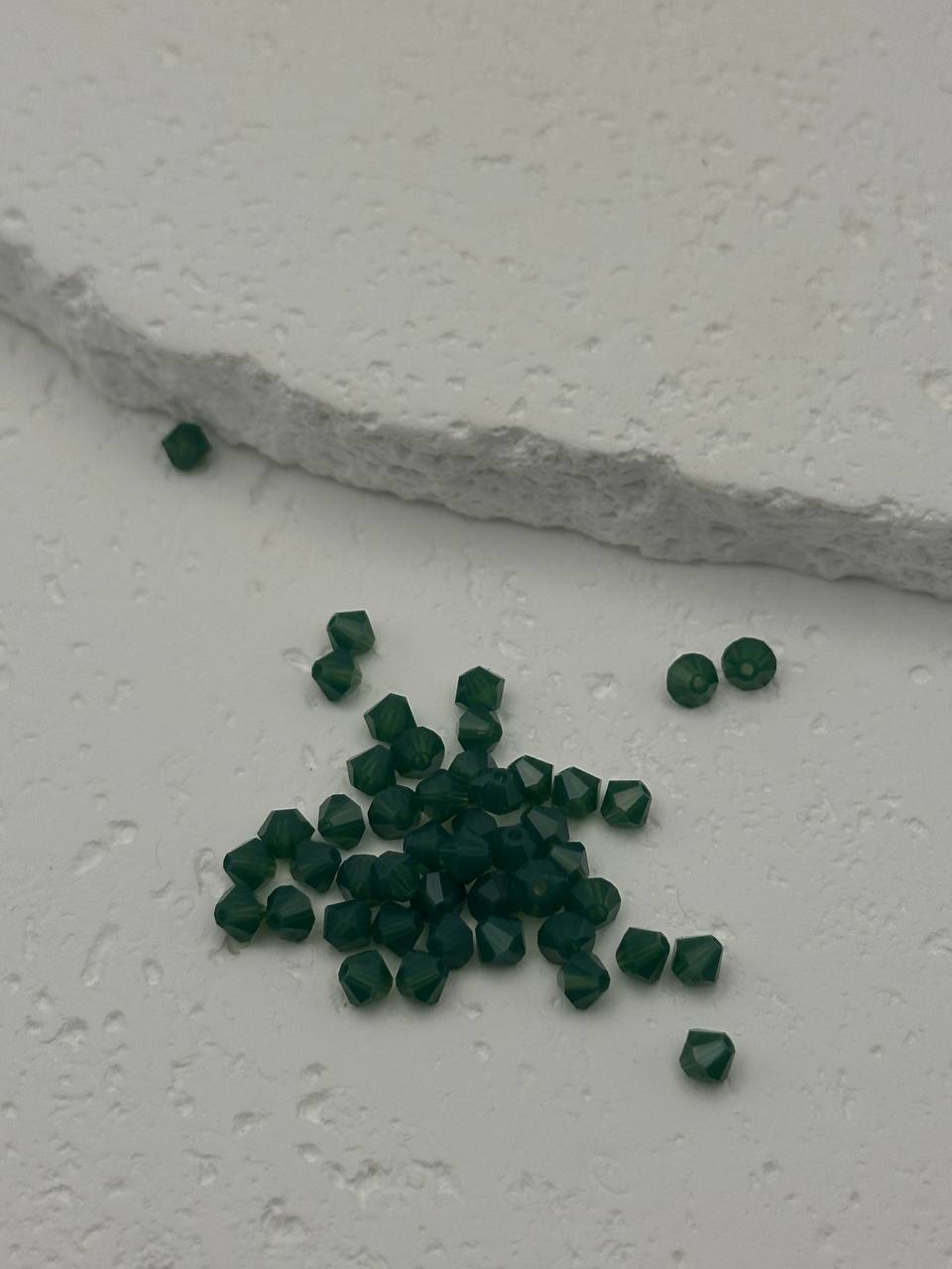 Green gemstones on a textured white surface